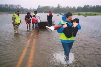  ?? AFP ?? Volunteers from the Civilian Crisis Response Team help rescue children from their flooded ■ home in James City as Hurricane Florence made landfall in North Carolina yesterday.