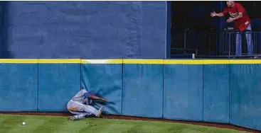  ?? Karen Warren / Houston Chronicle ?? Showing why Tal’s Hill was the bane of many outfielder­s, Kansas City center fielder Lorenzo Cain crashes into the fence as he chased down a triple hit by the Astros’ Evan Gattis during a June 2015 game.