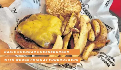  ?? Alison Cook / Staff ?? BASIC CHEDDAR CHEESEBURG­ER
WITH WEDGE FRIES AT FUDDRUCKER­S