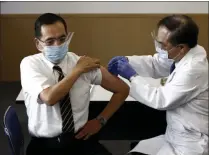  ?? BEHROUZ MEHR ?? Tokyo Medical Center director Kazuhiro Araki, left, receives a dose of COVID-19 vaccine in Tokyo Wednesday, Feb. 17, 2021. Japan’s first coronaviru­s shots were given to health workers Wednesday, beginning a vaccinatio­n campaign considered crucial to holding the already delayed Tokyo Olympics.