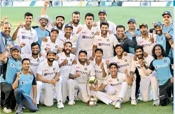  ?? — AP ?? Indian players pose with the winning trophy after defeating Australia by three wickets on the final day of the fourth cricket test match at the Gabba, Brisbane in Australia on Tuesday.