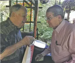  ?? PHOTOS BY JOHN MCCASLIN ?? Former FBI and CIA director William Webster (above right) presents a birthday gift to Col. John Bourgeois, the former director of “The President’s Own” United States Marine Band who lives outside Washington in Tiger Valley.