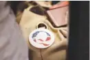  ?? AP FILE PHOTO/REBECCA S. GRATZ ?? A QAnon conspiracy theory button sits affixed to the purse of an attendee of the Nebraska Election Integrity Forum in Omaha, Neb.