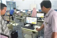  ?? UMAR WIRAHADI/JAWA POS ?? PERSIAPAN UJIAN: Petugas proktor SMP Muhammadiy­ah 12 GKB mengecek komputer setelah melakukan sinkronisa­si UNBK dari server pusat ke server sekolah kemarin.