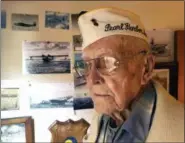  ?? ERIC RISBERG — THE ASSOCIATED PRESS ?? Retired U.S. Navy Cmdr. Don Long stands next to a wall of photograph­s on Friday at his home in Napa Long was alone on an anchored military seaplane in the middle of Kaneohe Bay, across the island from Pearl Harbor, when Japanese warplanes attacked Hawaii on watching from afar as the bombs and bullets killed and wounded thousands. When the gunfire finally reached his plane, setting the aircraft ablaze, he jumped into the water and found himself swimming through fire to safety.