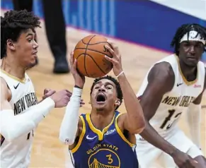  ?? — aP ?? Let me go: Golden state Warriors guard Jordan Poole (3) goes to the basket between new Orleans Pelicans centre Jaxson Hayes (left) and guard Kira Lewis Jr. in the nBa game.