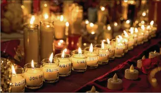  ?? GREG LOVETT / THE PALM BEACH POST ?? The names of the 17 people who were shot and killed by a gunman at Marjory Stoneman Douglas High School are written on candles at a memorial in Parkland, Fla., Thursday.