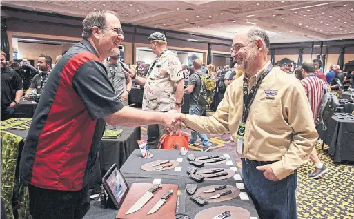  ?? BRIDGET BENNETT THE WASHINGTON POST ?? At a Las Vegas gathering last month, knife maker Douglas Stacie, left, thanks Doug Ritter, chair of Knife Rights, for his successes in repealing knife laws.