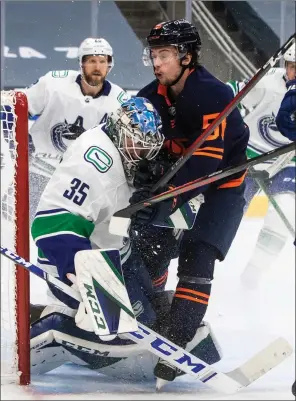  ?? The Canadian Press ?? Edmonton Oilers’ Kailer Yamamoto runs into Vancouver Canucks goalie Thatcher Demko during second-period NHL action in Edmonton on Thursday.