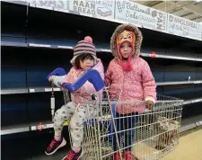  ?? Photo: Caroline Quinn ?? Fiadh Conway, left, and sister Maisie, from Swords, at the empty bread shelves in Tesco Airside, Dublin.