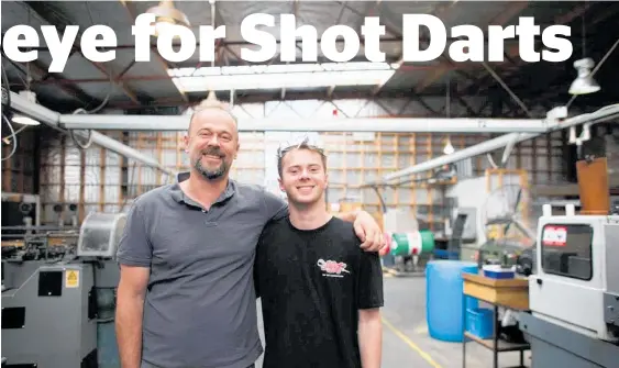  ??  ?? Shot Darts director Peter McCormick with son Ryan, who spends holidays working in the factory.