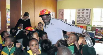  ??  ?? LEARNING CURVE Kids at the Nomsa Mapongwana Primary School with Lembeni, above, and below, Lembeni describes the life of a shack-dweller to the group.