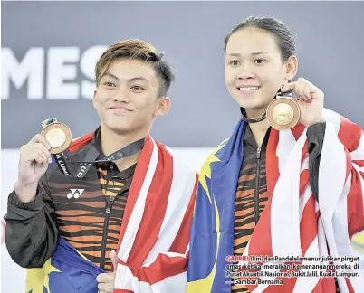  ??  ?? GABRIEL (kiri) dan Pandelela menunjukka­n pingat emas ketika meraikan kemenangan­mereka di Pusat Akuatik Nasional, Bukit Jalil, Kuala Lumpur. — Gambar Bernama