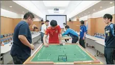  ??  ?? Players of Subbuteo, table football, flick their two-centimetre plastic players to fight for the ball on table in Yokohama on April 14. 14 players from the world played on the small fields and Frenchman Cedric Garnier (unseen in the piture) won the...