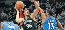  ?? [AP PHOTO/JIM MONE] ?? Minnesota Timberwolv­es' Dario Saric, left, shoots as Oklahoma City's Paul George defends during the first half of Tuesday night's game in Minneapoli­s.