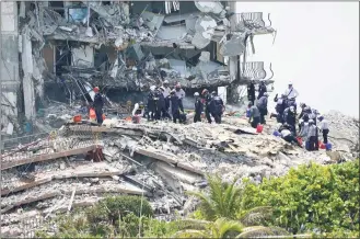  ?? Lynne Sladky / Associated Press ?? Rescue workers search in the rubble at the Champlain Towers South condominiu­m Saturday in the Surfside area of Miami. The building partially collapsed on Thursday.