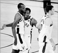  ?? DOUGLAS P. DEFELICE/GETTY ?? Khris Middleton, left, celebrates with Eric Bledsoe during the Buck’s victory Sunday. Bledsoe scored 36 points and hit a big 3-pointer late in OT.