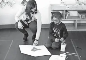  ?? COURTNEY HERGESHEIM­ER/COLUMBUS DISPATCH ?? Ayden White, 5, works with Amanda Lacass on his “hero shield” during an exercise designed to boost self-esteem in a class earlier this year at St. Vincent Family Center. The pandemic has increased stress and created a surge in mental health issues among children already growing up in poverty and/or crime-ridden areas.