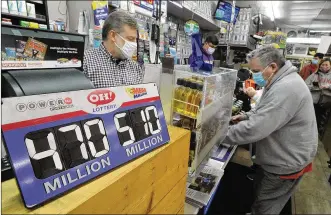  ?? MARSHALL GORBY / STAFF ?? Michael Sliger (left), manager of Bee-Gee’sMinit Market in Kettering, helps customers with their purchase ofMega Millions tickets on Thursday.
