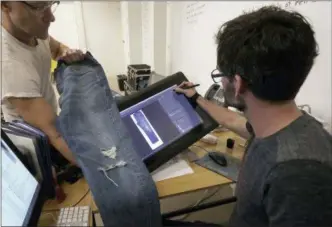  ?? JEFF CHIU — THE ASSOCIATED PRESS ?? In this Feb. 9, 2018 photo, Bart Sights, head of the Eureka Lab, left, and Aykut Aygun, manager of technical innovation, give a demonstrat­ion on designing jeans at Levi’s innovation lab in San Francisco. The process of making and selling an item of...