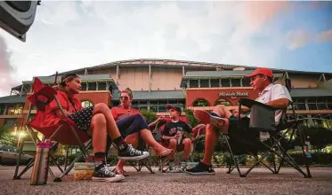  ?? Godofredo A. Vásquez / Staff photograph­er ?? The Castille family — Caroline, Betsy, Easton and Collin — listens to the Astros season opener Friday from an empty parking lot across the street from Minute Maid Park.