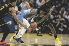  ?? STEPHEN LAM/AP ?? Memphis Grizzlies guard Ja Morant dribbles the ball as he is defended by Golden State Warriors guard Jordan Poole, left, and forward Andrew Wiggins during the fourth quarter in Game 3 of an NBA basketball playoffs Western Conference semifinal on Saturday.