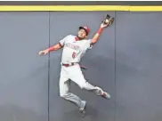  ?? ASSOCIATED PRESS ?? Billy Hamilton of the Reds catches Ryan Braun’s fly ball at the wall Friday night at Miller Park.