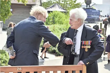  ?? ANTHONY DEVLIN/AP ?? British Prime Minister Boris Johnson greets veteran Bill Redston at a service of remembranc­e to mark the 75th anniversar­y of V-J Day on Saturday.