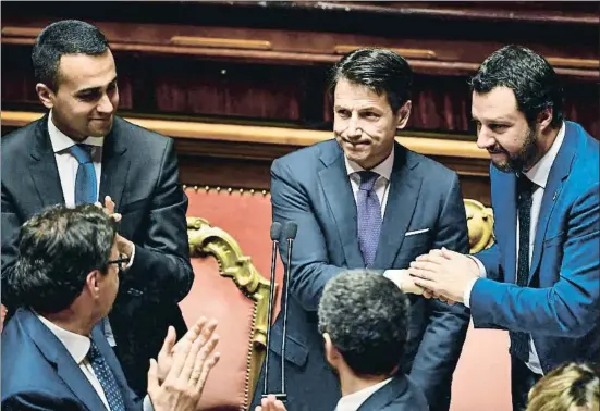  ?? ANDREAS SOLARO / AFP ?? Giuseppe Conte, entre Luigi Di Maio y Matteo Salvini, es felicitado tras ganar ayer la confianza obtenida en el Senado