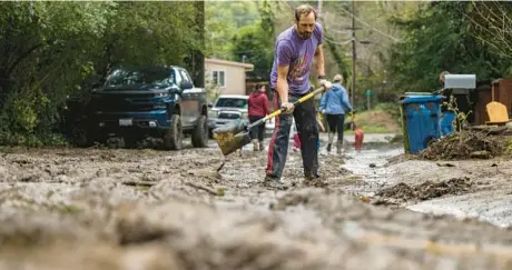  ?? NIC COURY/AP ?? Matt O’Brien clears mud from a friend’s driveway Tuesday in Felton, Calif., after the San Lorenzo River overflowed.