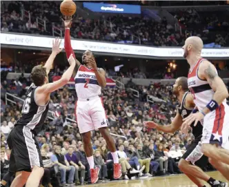  ??  ?? WASHINGTON: Washington Wizards guard John Wall (2) takes a shot against San Antonio Spurs center Pau Gasol, of Spain, (16) during the first half of an NBA basketball game, Saturday, in Washington. Also seen is Washington Wizards center Marcin Gortat,...