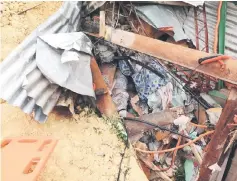  ?? — AFP photo ?? A dead body is seen amongst the rubble after the landslide.