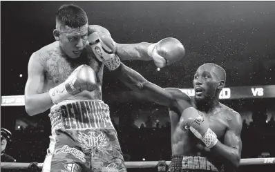  ?? NATI HARNIK / AP ?? Terence Crawford lands a straight right on Jose Benavidez during their WBO welterweig­ht title bout in Omaha, Nebraska, on Saturday. Crawford retained his title with a 12th-round TKO.