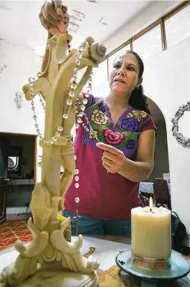  ?? Bob Owen / San Antonio Express-News ?? Maria Guadalupe Martinez Vargas, mother of Jose, who made it out of the human smuggling trailer, prays daily for her son with her rosary at a small shrine in her home in Calvillo, Mexico, a town west of Aguascalie­ntes.