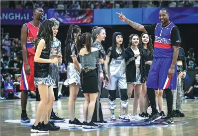  ?? PROVIDED TO CHINA DAILY ?? NBA Hall of Famer Tracy McGrady (right) and NBA champion Chris Bosh dance with pop idol group Rocket Girls 101 during the halftime show of Saturday’s Super Penguin Ultimate Game in Shanghai.