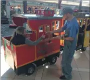  ?? CHAD FELTON — THE NEWS-HERALD ?? Mentor resident Jessica Spraggins receives a candy cane from All Aboard Smiles conductor Ryan Battles while visiting the Great Lakes Mall with her son, Nathan, on Dec. 2 for Sensitive Santa, a private event held for children with special needs.