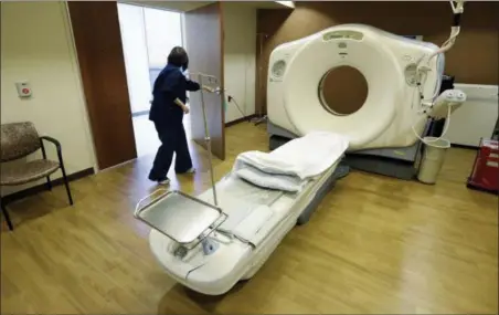  ?? M. SPENCER GREEN — THE ASSOCIATED PRESS FILE ?? A CT scan technician prepares for a patient at the Silver Cross Emergency Care Center in Homer Glen, Ill. The Trump administra­tion is quietly trying to weaken radiation rules, relying on scientific outliers who argue that a little radiation damage is actually good for you — like a little bit of sunlight.