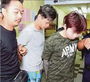  ?? BERNAMA PIC ?? Yip Kah Hou (right) and Gan Jia Ji (centre) taken into the Johor Baru magistrate’s court yesterday.