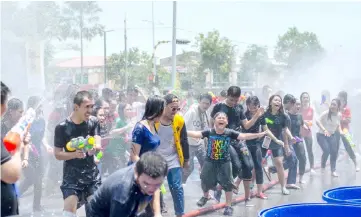  ??  ?? Groups of young people break into an impromptu dance which has the rest joining in as they are drenched by water drawn from a mobile water tanker.