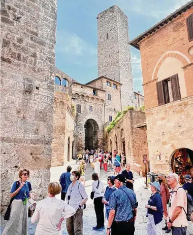  ?? Photos by Nancy Nathan / for the Washington Post ?? A Smithsonia­n Journeys tour group listens to a guide on an excursion to San Gimignano.