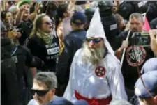  ?? STEVE HELBER — THE ASSOCIATED PRESS ?? This photo shows members of the KKK escorted by police past a large group of protesters during a KKK rally in Charlottes­ville, Va. Some white Southerner­s are again advocating for what the Confederac­y tried and failed to do