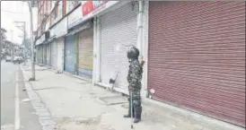  ?? PTI ?? A security personnel stands guard during shutdown in Srinagar on Thursday.