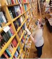  ??  ?? Jordan Vroon takes inventory in Parnassus Books in Nashville.