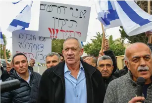  ?? (Flash90) ?? FORMER IDF chief of staff Benny Gantz with members of the Druze community and activists outside his home yesterday in Rosh Ha’ayin, during a protest against the Nation-State Law.