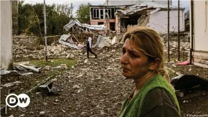  ??  ?? Una habitante de Stepanaker­t, en Nagorno Karabaj frente a las ruinas de su casa.