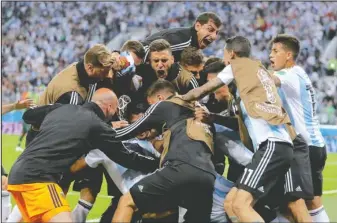  ?? The Associated Press ?? LAST GASP: Argentina players celebrate defender Marcos Rojo’s 86th-minute winner in a 2-1 victory against Nigeria Tuesday in St. Petersburg, Russia, to place second in Group D and advance to the knockout rounds of the 2018 FIFA World Cup.