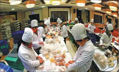  ?? WANG JIANZHONG / FOR CHINA DAILY ?? Restaurant employees prepare takeaway Lunar New Year’s Eve dinner dishes at Deyuelou Restaurant in Suzhou, Jiangsu province.
