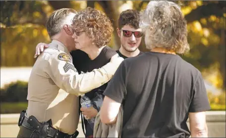  ?? Al Seib Los Angeles Times ?? VENTURA COUNTY Sheriff’s Sgt. Eric Buschow hugs Susan Schmidt-Orfanos, mother of shooting victim Telemachus Orfanos, after a news conference in Thousand Oaks on Tuesday. The rampage “was a terrifying experience for everyone involved,” Sheriff Bill Ayub said