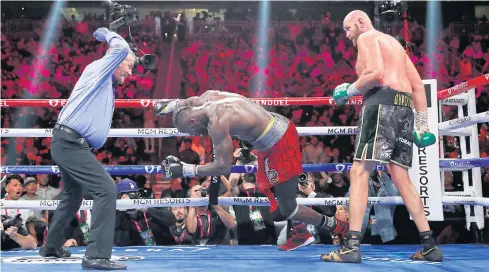  ?? REUTERS ?? Tyson Fury, right, knocks down Deontay Wilder during the 11th round of their WBC heavyweigh­t title bout at T-Mobile Arena in Las Vegas.