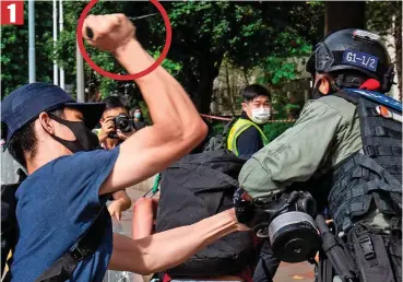  ??  ?? ■ 1
Clash: A protester raises his knife (circled) as police and protesters battle in Hong Kong Bloodied: The wounded officer after Wednesday’s clash